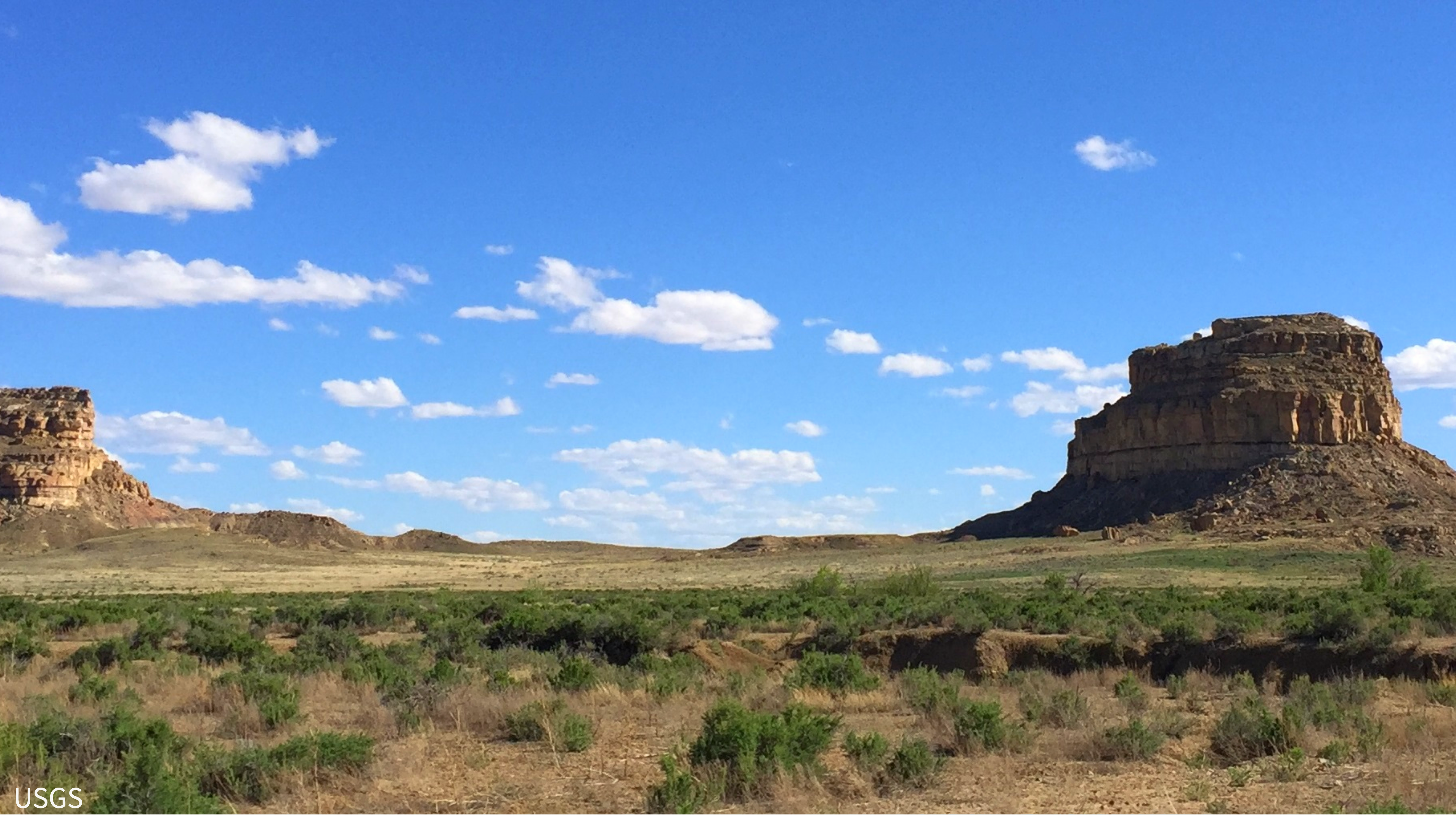 two butte landforms across from one another in the desert during the day.